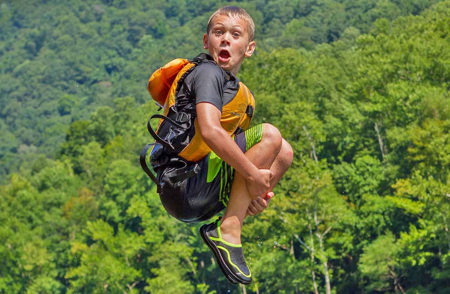 Boy cannon balling on a rafting trip